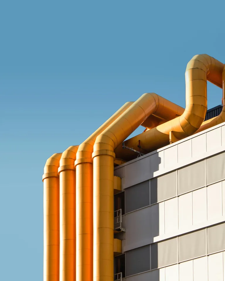 Industriegebäude mit orangefarbenen Rohrleitungen